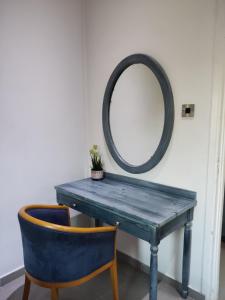 a dressing table with a mirror and a blue chair at Wooden House in Paphos City