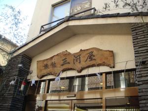 a building with a sign on the side of it at Ryokan Mikawaya in Tokyo
