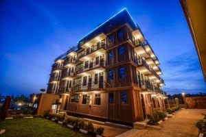 a large building with lights on it at night at Mlex Hotel in Kampala