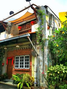 una casa di mattoni rossi con piante sopra di LEJU 21 樂居 Explore Malacca from a riverside house a Malacca