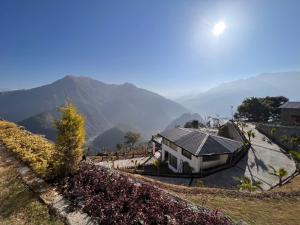 a house on a hill with mountains in the background at Dandelion By The Hills in Lakhwār