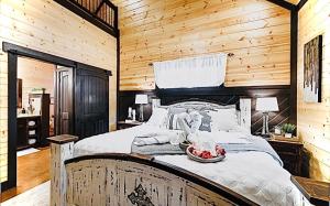 a bedroom with a large bed with a wooden wall at Knotty and Nice Luxury Cabin in Broken Bow