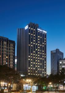 un edificio alto en una ciudad por la noche en Nine Tree Hotel Dongdaemun en Seúl