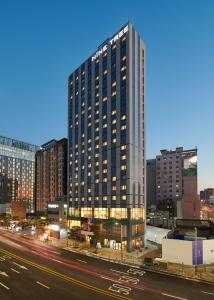 um edifício alto ao lado de uma rua da cidade em Nine Tree Hotel Dongdaemun em Seul