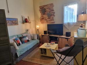 uma sala de estar com um sofá e uma televisão em Torreilles plage: villa atypique bord de mer méditerranée em Torreilles