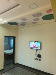 Zimmer mit einem Flachbild-TV an der Wand in der Unterkunft Hallima Home Stay Purpose Guest Bungalow House 1 in Pudukkottai