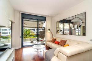 a living room with a couch and a table at Sitges Spaces Garden Paradise 3 bedroom, 3 bathroom, huge PRIVATE garden-terrace, pool- sleeps up to 8 in Sitges