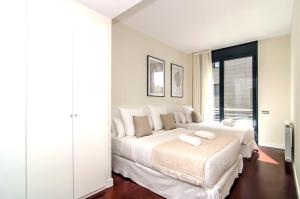 a bedroom with a large bed with two towels on it at Sitges Spaces Garden Paradise 3 bedroom, 3 bathroom, huge PRIVATE garden-terrace, pool- sleeps up to 8 in Sitges +82 photos