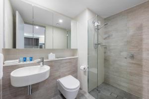 La salle de bains est pourvue de toilettes, d'un lavabo et d'une douche. dans l'établissement Meriton Suites Southport, à Gold Coast