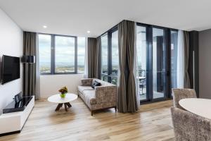 a living room with a couch and a table at Meriton Suites Southport in Gold Coast