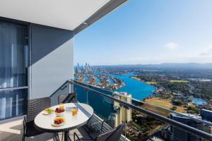 un balcón con una mesa con comida y bebidas. en Meriton Suites Southport en Gold Coast