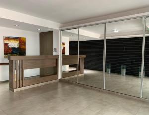 - un hall avec des murs en verre et un bureau en bois dans l'établissement Locación Jujuy, à San Salvador de Jujuy