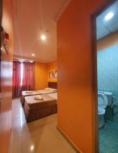 a hotel room with two beds and a toilet at Highway Budget Hotel in Ipoh