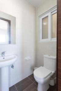 a white bathroom with a toilet and a sink at F5-1 Double room with private bathroom and balcony in shared Flat in Msida