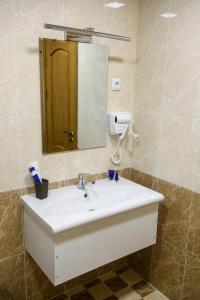 y baño con lavabo blanco y espejo. en Hotel Shumon en Dusambé