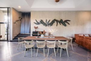 a dining room with a wooden table and chairs at Pirom Garden Private Villa in North Pattaya