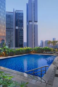 a swimming pool in a city with tall buildings at Citadines Sudirman Jakarta in Jakarta