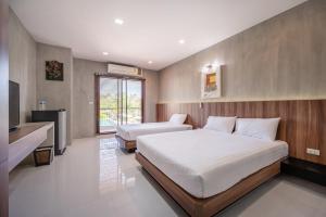 a hotel room with two beds and a television at Pirom Garden Private Villa in Pattaya North +56 photos