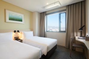 um quarto de hotel com duas camas e uma janela em Nine Tree Hotel Dongdaemun em Seul