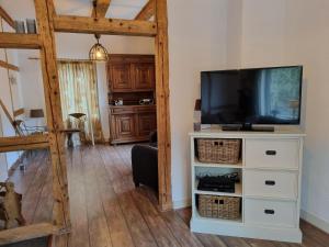 ein Wohnzimmer mit einem TV auf einer weißen Kommode in der Unterkunft Beautiful apartment in a former coach house in the Harz in Elbingerode
