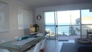 a living room with a glass desk and a balcony at Unit 5 Sanctuary Shores, Kings Beach - Free Wifi! in Caloundra