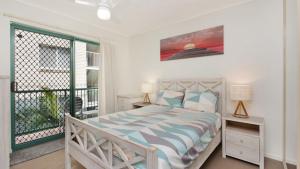 a bedroom with a bed and a balcony at Unit 2 'fair Haven' Kings Beach in Caloundra