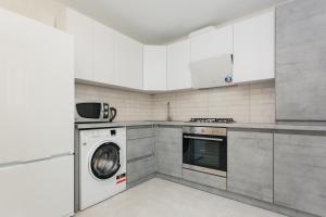 una cucina con lavatrice e lavatrice di Квартира ЛАВИНА Room a Sumy