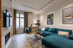 ein Wohnzimmer mit einem blauen Sofa und einem Tisch in der Unterkunft Max Central Apartment in Belgrad
