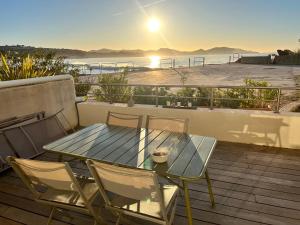 - une table et des chaises sur une terrasse avec vue sur l'océan dans l'établissement plage st jean RESIDENCE LE GOLFE D AZUR, à La Ciotat