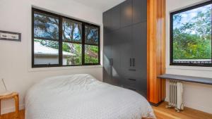 - une chambre avec un lit et 2 grandes fenêtres dans l'établissement Barefoot - Pearl Beach Wifi Family Friendly, à Pearl Beach