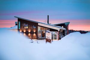 ein Gebäude im Schnee mit vielen Fenstern in der Unterkunft Camp Ripan in Kiruna