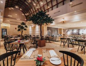a restaurant with tables and chairs and a tree at Idou Anfa Hôtel & Spa in Casablanca
