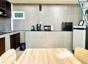 a kitchen with a stove top oven and a microwave at BE Rendez Vous Hotel in Patong Beach