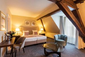 um quarto de hotel com uma cama, uma mesa e cadeiras em Dukes' Arches Brugge Adults only em Bruges