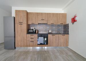 a kitchen with wooden cabinets and a refrigerator at F7 Modern and Bright Apartment in Malta in Msida
