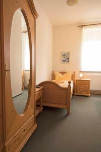 um quarto com uma cama e um espelho grande em Bürgerhaus Niesky em Niesky