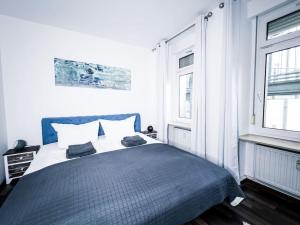 una camera con un letto blu e bianco e due finestre di Shabby Chic im hippen Reudnitz - Zentral & Ruhig a Lipsia