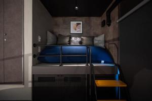 ein kleines Schlafzimmer mit einem Bett mit einem blauen Kissen in der Unterkunft trive ozone バンテリンドーム ナゴヤ近く 都心部好アクセス 大曽根駅 徒歩3分 in Nagoya