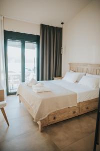 a bedroom with a large bed and a large window at Elia Luxury Suites in Plataria +101 photos