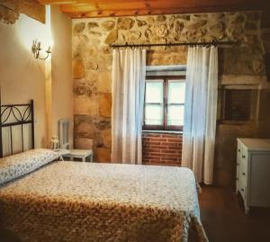 een slaapkamer met een bed en een raam bij La Posada de Maria in Villanueva de la Peña