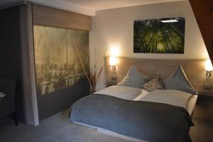 1 dormitorio con 1 cama y una pintura en la pared en Hotel Neue Stuben en Wolfsburg