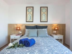 a bedroom with a bed with blue pillows on it at Holidays2Malaga Mendoza Terrace & Sea View in Málaga