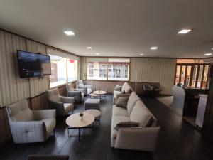 a living room with couches and tables and a tv at Hotel Querol in Valderrobres