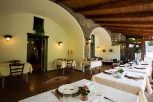 a restaurant with white tables and chairs and a room at Agriturismo Il Convento in Massa Lubrense