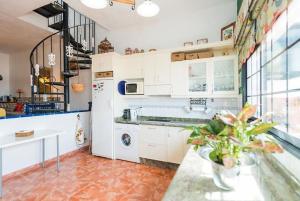 a kitchen with white cabinets and a white refrigerator at Vista Faro Sardina in Las Palmas de Gran Canaria