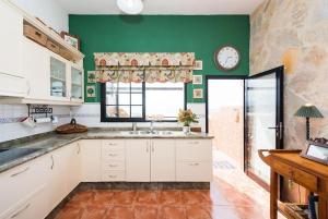 una cocina con fregadero y un reloj en la pared en Vista Faro Sardina, en Las Palmas de Gran Canaria