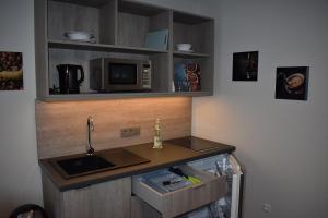 a kitchen counter with a sink and a microwave at Hotel Neue Stuben in Wolfsburg