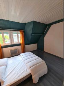 een groot bed in een kamer met een groene muur bij Aurélien et Charlotte in Ponts-et-Marais