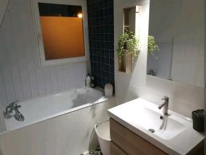 een badkamer met een bad, een toilet en een wastafel bij Aurélien et Charlotte in Ponts-et-Marais