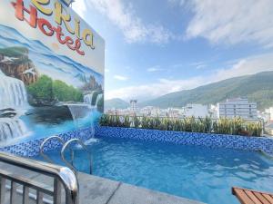 a swimming pool with a mural on the side of a building at MERIA Hotel Quy Nhơn in Quy Nhon